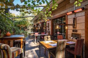 an outdoor patio with tables and chairs and windows at Mercure Tbilisi Old Town in Tbilisi City