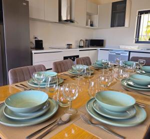 a table with plates and wine glasses on it at Entire villa with private pool and seaview Albion Mauritius in Albion