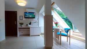 a kitchen with a table and a chair and a window at Paula Wellness & SPA in Pobierowo