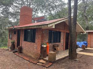 een bakstenen huis met een schoorsteen en een veranda bij Cabaña en Villa del carbón in Villa del Carbón +1 foto