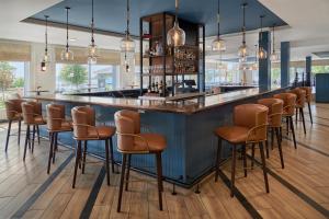 a bar with brown stools in a room at Hotel Canandaigua, Tapestry Collection By Hilton in Canandaigua
