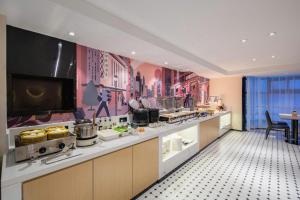 a large kitchen with a counter with food on it at City Comfort Inn Nanning Normal University Mingxiu Metro Station in Nanning