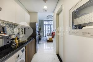 a kitchen with white cabinets and a counter top at Bloomfields Casual Stu in The Gate in Abu Dhabi