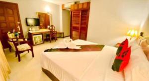 a hotel room with a bed and a dining room at Midland Hotel in Phnom Penh
