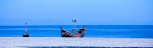 two boats are tied to the shore of the ocean at Hotel Ovisar Cox'sBazar in Cox's Bazar