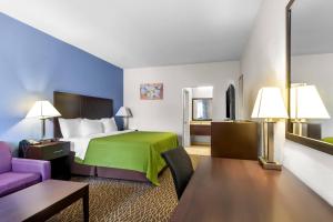 ein Hotelzimmer mit einem Bett mit grüner Tagesdecke in der Unterkunft Econo Lodge in Bryan + 43 Fotos