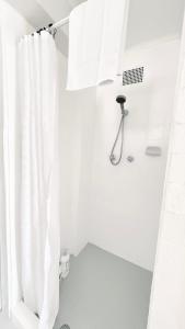 a bathroom with a shower with a white shower curtain at Garden View Homestay Single Ensuite Room in Catalina