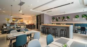 un ristorante con tavoli e sedie e un bar di Home Inn Selected Xiamen University Zhongshan Road a Xiamen