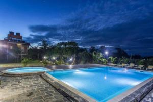 a swimming pool in a resort at night at Center Park Resort in Sauraha