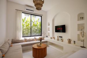 ein Wohnzimmer mit einer Couch und einem Fenster in der Unterkunft CosyCalm 2bd Villa wRooftop 4 mins Cemagi Beach in Cemagi