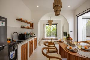 eine Küche mit einem Tisch, Stühlen und einer Theke in der Unterkunft CosyCalm 2bd Villa wRooftop 4 mins Cemagi Beach in Cemagi