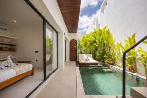 ein Schlafzimmer mit einem Bett und einem Swimmingpool in der Unterkunft CosyCalm 2bd Villa wRooftop 4 mins Cemagi Beach in Cemagi