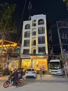 Un edificio alto con coches aparcados delante. en Hoang Ngoc Hotel, en Dồng Văn