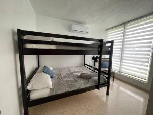 Un dormitorio con dos literas en una habitación. en Casa ValeAna Peaceful house, en Sabana Abajo