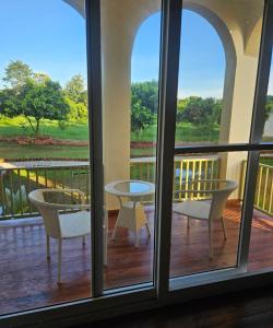 a room with a balcony with a table and chairs at Evaan Litchi Orchards and Resorts, Corbett in Rāmnagar