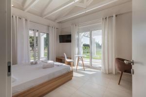 a bedroom with a bed and a large window at White Villas in Dhounaíika +81 photos