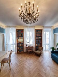 a living room with a chandelier and a table at Casa Saba Trieste Luxury Apartment with terrace in Trieste