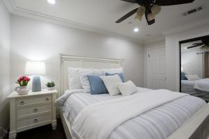 a white bedroom with a large bed and a mirror at Destination #22 in Anaheim