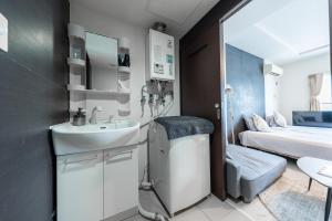 札幌市にあるYELLOWの洗面台とベッドのある小さなバスルーム