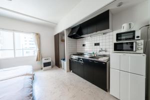 札幌市にあるYELLOWのシンクと電子レンジのある小さなキッチン