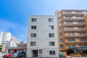 札幌市にあるYELLOWの前に車が駐車されている白い建物