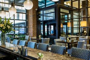 a restaurant with blue chairs and tables and windows at Archer Hotel New York in New York