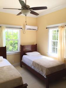a bedroom with two beds and a ceiling fan at Mangrove Cay Sea View Villas in Behring Point