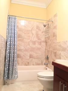 a bathroom with a tub and a toilet and a sink at Mangrove Cay Sea View Villas in Behring Point