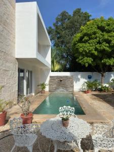 a house with a pool and a table and chairs at Casa D'Sauza's in Tekax de Álvaro Obregón
