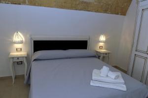 a bedroom with a bed with two towels on it at Palazzo Piccioli in Gallipoli +144 photos