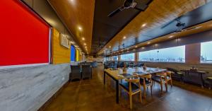 a restaurant with tables and chairs and a large window at Zip By Spree Hotels Grand Legacy Prime in Dehradun +29 photos