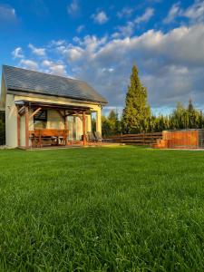a large yard with a pavilion with a green lawn at Domek Na Miodowej in Sulistrowiczki