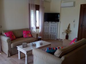 a living room with two couches and a coffee table at Villa Androniki in Longos
