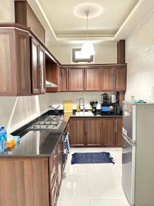 a kitchen with wooden cabinets and a stainless steel refrigerator at Residence ADE in Libreville