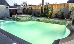 une piscine avec de l'eau bleue dans une cour arrière dans l'établissement Destination #34, à Santa Ana