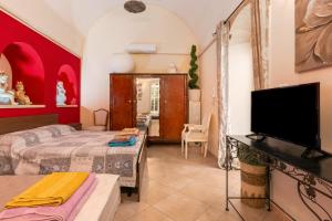 a bedroom with two beds and a flat screen tv at Palazzo Costantini in San Donato di Lecce