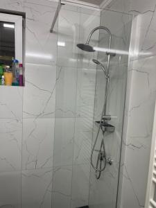 a bathroom with a shower with white marble walls at Escape Aparthotel in Suceava +40 photos