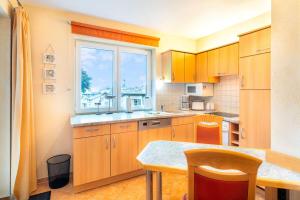 a kitchen with wooden cabinets and a window at Villa Sabinium Wohung 05 in Heringsdorf
