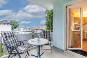 a patio with two chairs and a table on a balcony at Villa Sabinium Wohung 05 in Heringsdorf
