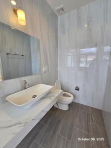 a white bathroom with a sink and a toilet at Goldena Residence Pool Villas in Kamala Beach
