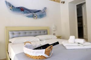 Palazzo Piccioli في غالّيبولي: غرفة نوم بسريرين مع سلة على السرير