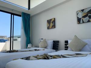 zwei Betten in einem Zimmer mit Fenster in der Unterkunft Laguna Parkside 5 bedroom villa with pool near the beach in Laguna Phuket + 9 Fotos