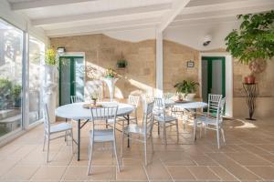 a patio with two white tables and chairs at Palazzo Costantini in San Donato di Lecce