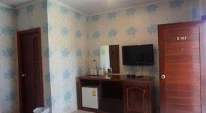 a room with a tv on the wall and a room with a door at The Park Nangrong Resort in Nang Rong