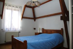 ein Schlafzimmer mit einem blauen Bett und einem Fenster in der Unterkunft Maison de Campagne à Levergies 