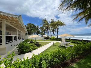 a house with a picnic table and an umbrella at Backyard Beach House Oceanfront Luxury 5 Bdr in Playa Hermosa