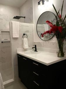 a bathroom with a sink and a vase with red flowers at Backyard Beach House Oceanfront Luxury 5 Bdr in Playa Hermosa