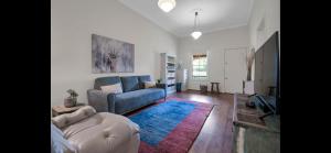 a living room with a blue couch and a rug at Tompson Apartment in Wagga Wagga