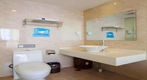 a bathroom with a toilet and a sink and a mirror at 7 Days Inn Chaozhou Chaofeng Road Bus Station in Chaozhou +84 photos