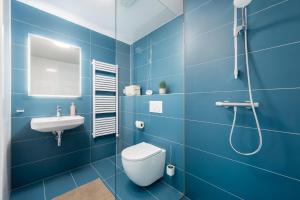a blue bathroom with a toilet and a sink at Internesto Brno HUB in Brno